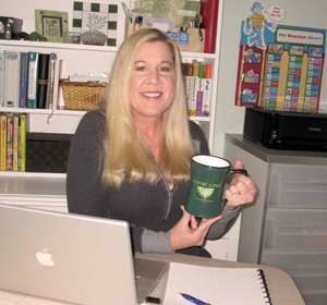 woman sitting at kitchen table with laptop computer and coffee mug