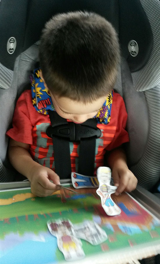 Boy playing with Billy Gorilly magnetic activity board in the car